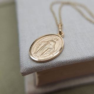 close up of gold miraculous medal and chain