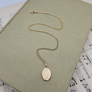 oval gold miraculous pendant and chain