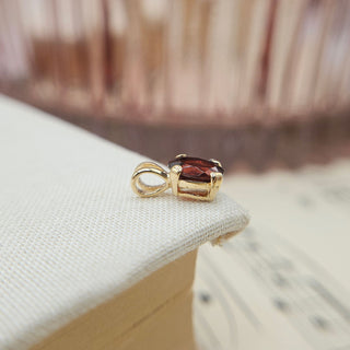 side profile of dainty garnet charm in 9K gold