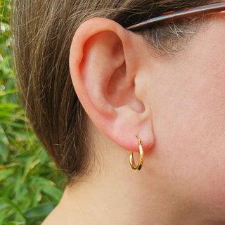 dainty gold creole hoops in ladies ear