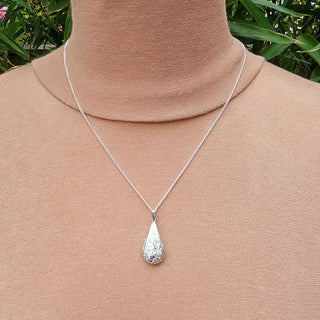 silver teardrop locket being worn