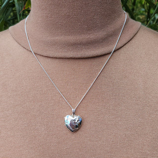 silver heart locket and chain being worn