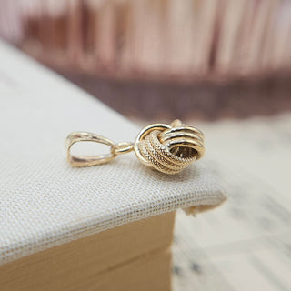 textured and polished finish on gold knot charm