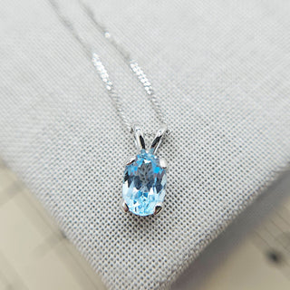 close up of blue oval topaz stone set in white gold