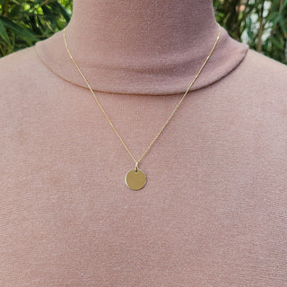 gold disc necklace being worn