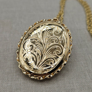 solid gold oval locket with floral spray design