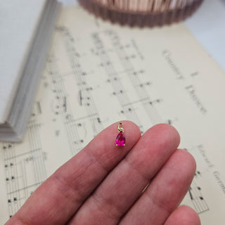 red cz charm in hand for scale
