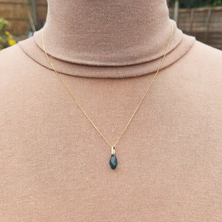 green crystal glass pendant worn as a necklace