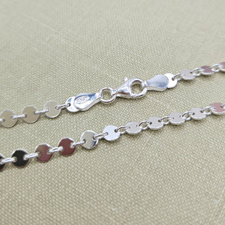 close up of silver disc chain anklet