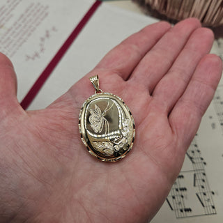 9ct gold locket in hand for scale