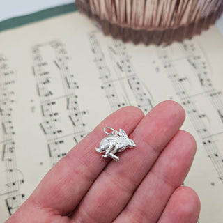 silver hare charm pendant in hand for scale