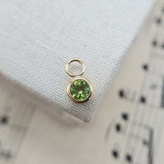 small round peridot stone set in solid gold