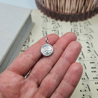 dainty st christopher pendant in hand for scale