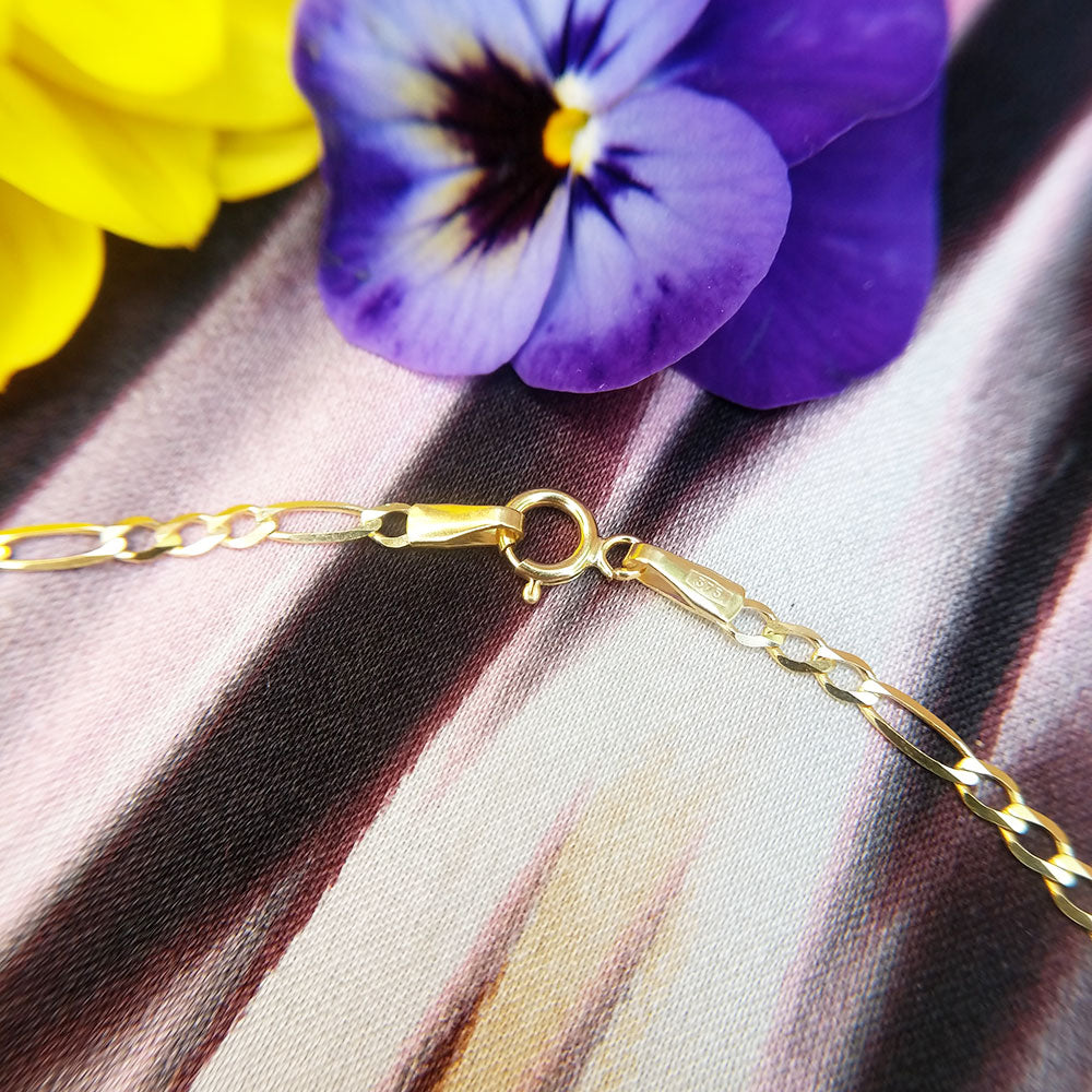 close up of anklet figaro links