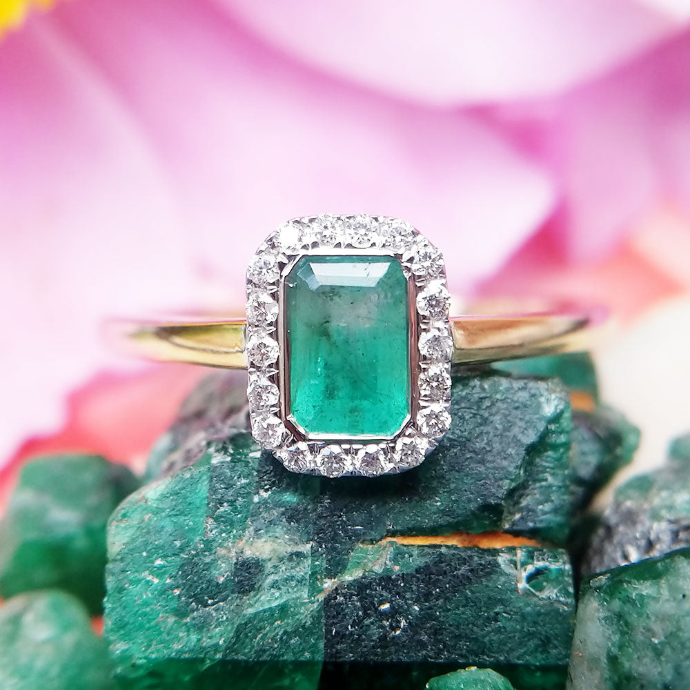 close up of emerald diamond cluster ring