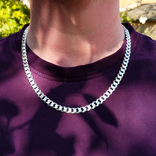 silver bevelled curb chain on man's neck