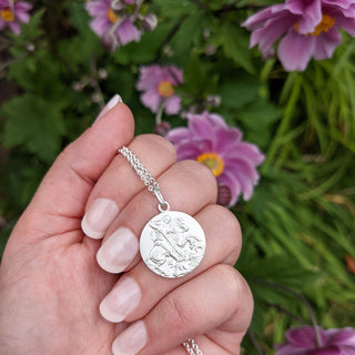 St George necklace in hand for scale