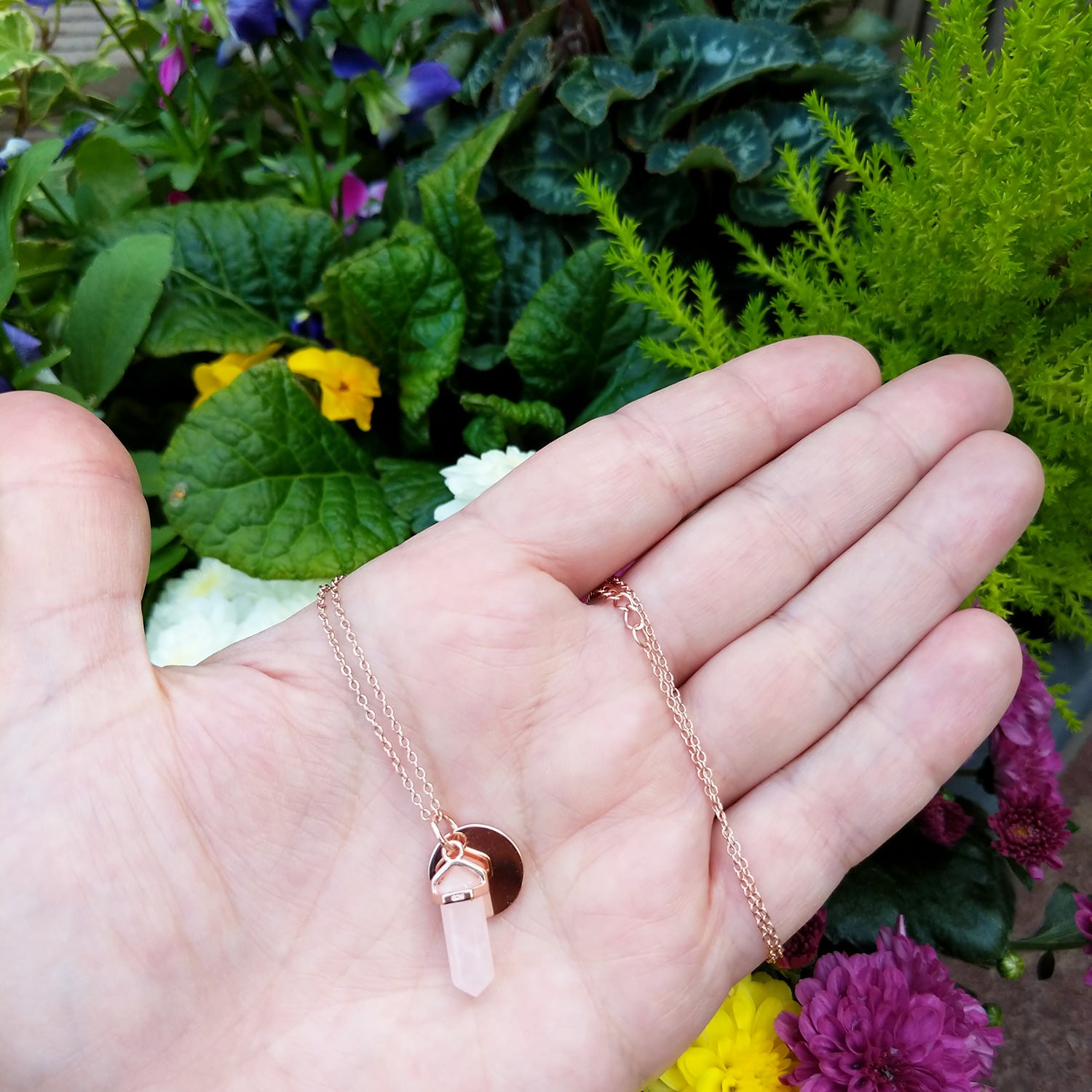 rose gold pendant necklace in hand for scale