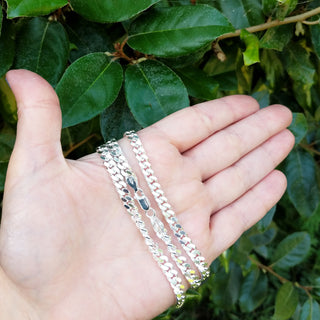 silver curb chain in hand for scale