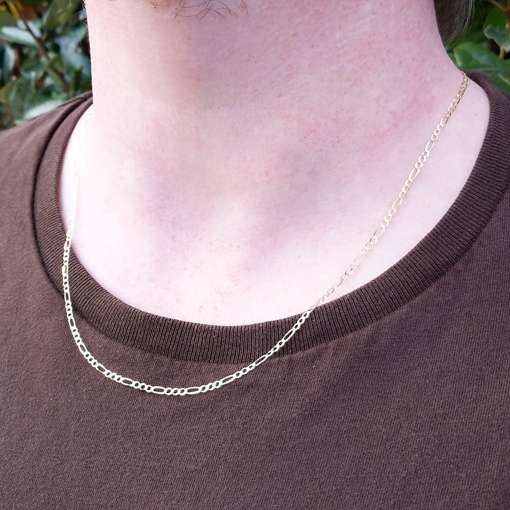 fine gold figaro chain on man's neck