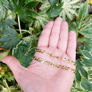 22 inch gold curb chain in hand for scale