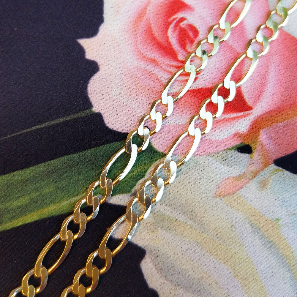 close up of gold figaro chain