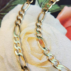 close up of gold figaro links