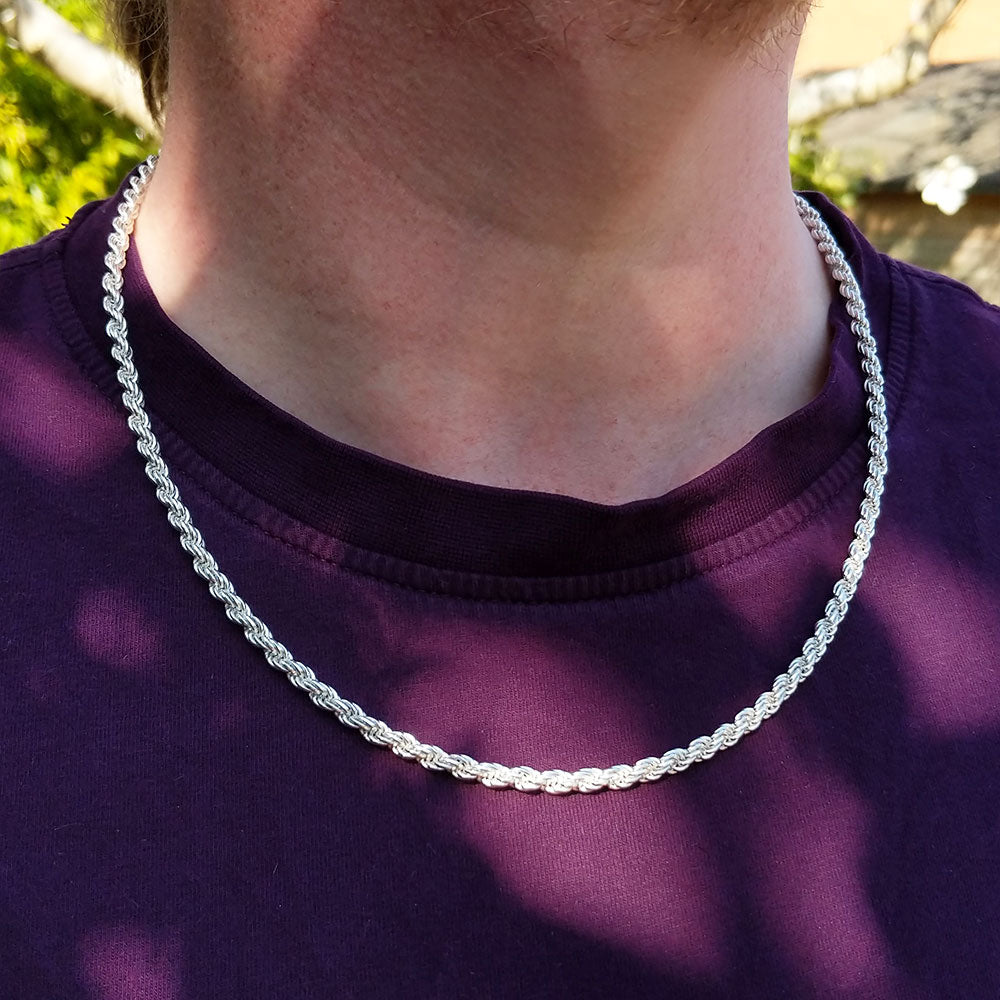 silver rope chain on man's neck