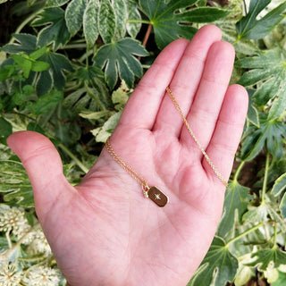 necklace in hand for scale