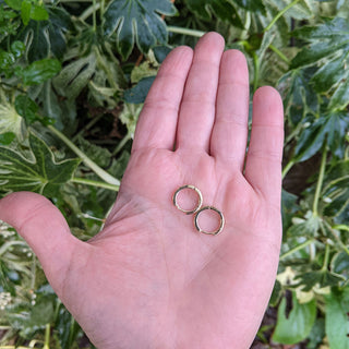 small huggie earrings in hand for scale