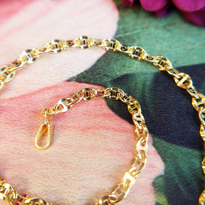close up of gold anchor links in bracelet