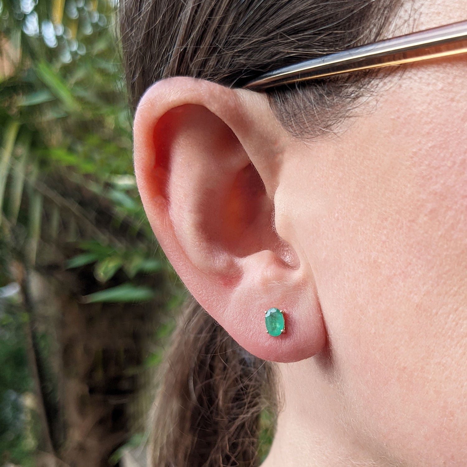 9ct gold and emerald stud earrings in ear