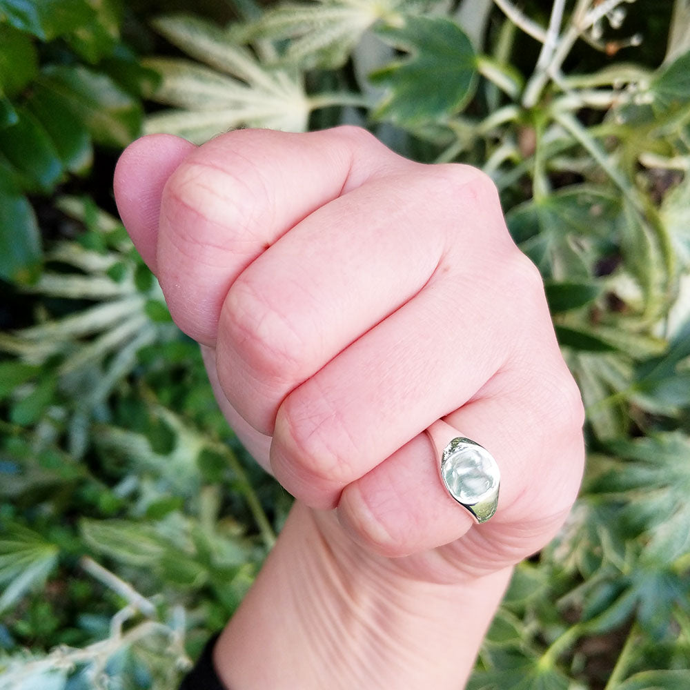silver signet ring on woman's hand
