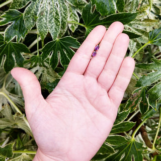 amethyst earrings in hand for scale