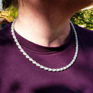 silver rope chain on man's neck