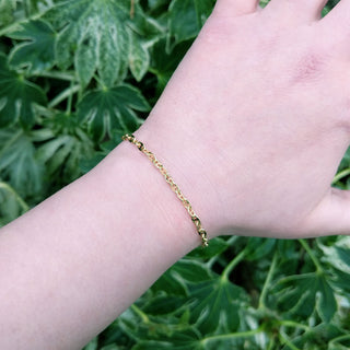 gold anchor bracelet on arm