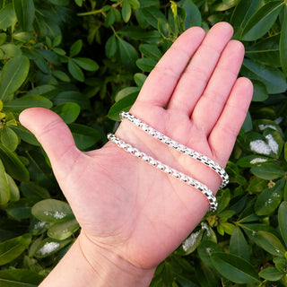 silver box chain necklace in hand for scale