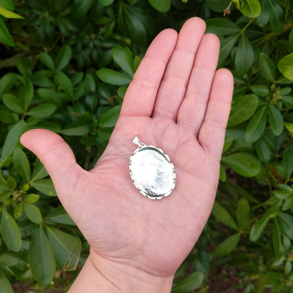 large locket in hand for scale