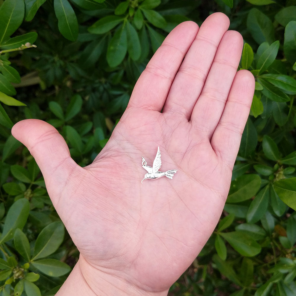 bird pendant in hand for scale
