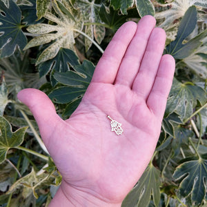 rose gold hamsa hand pendant in hand for scale