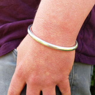 heavy torque bangle on man's wrist