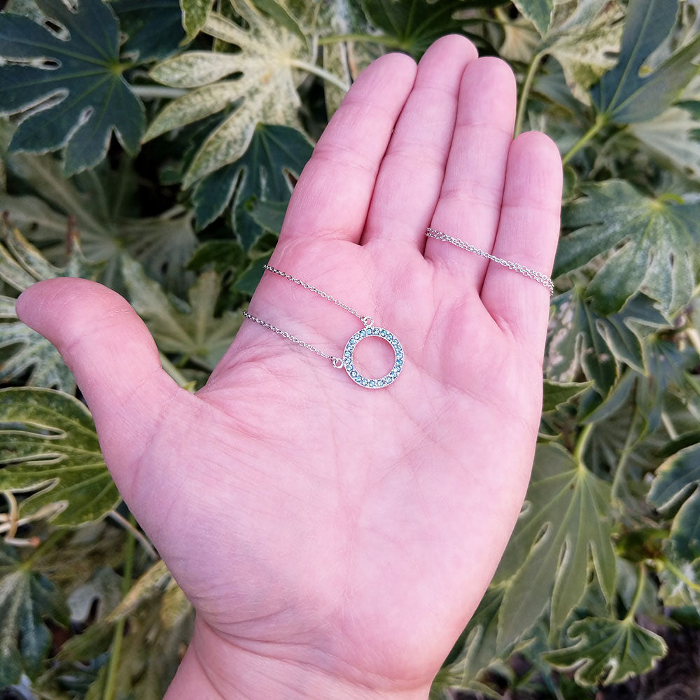 circle necklace in hand for scale