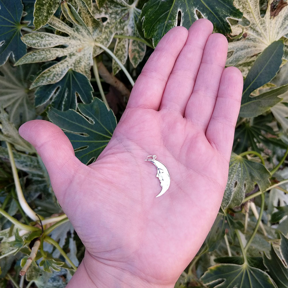 moon necklace in hand for scale