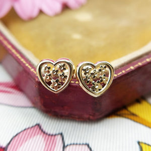 close up of yellow gold heart stud earrings