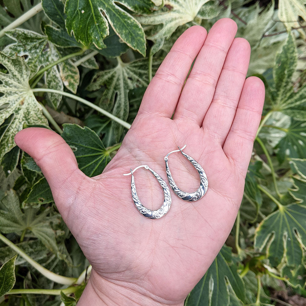 silver gypsy creoles in hand for scale