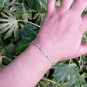 silver figaro bracelet on woman's wrist