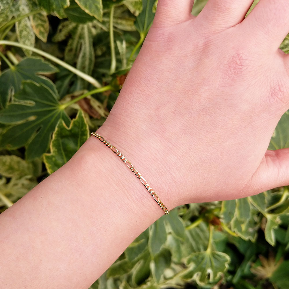 gold bracelet on woman's wrist for scale
