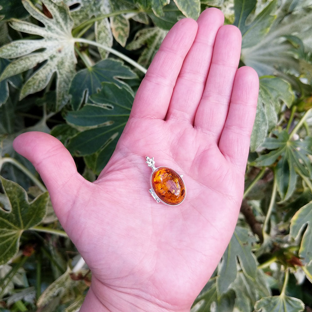 amber locket in hand for scale