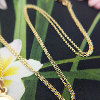 close up of solid gold trace chain with pendant