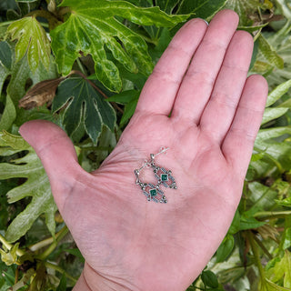 art deco earrings in hand for scale